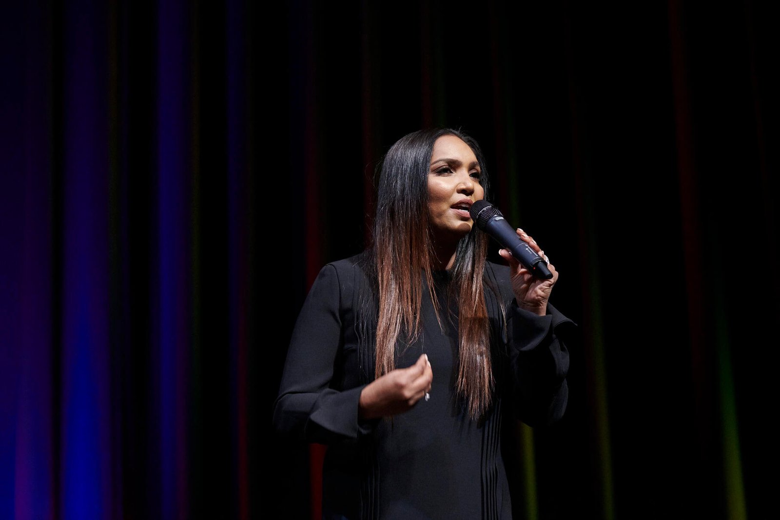 Norliza on stage holding microphone — keynote speaker
