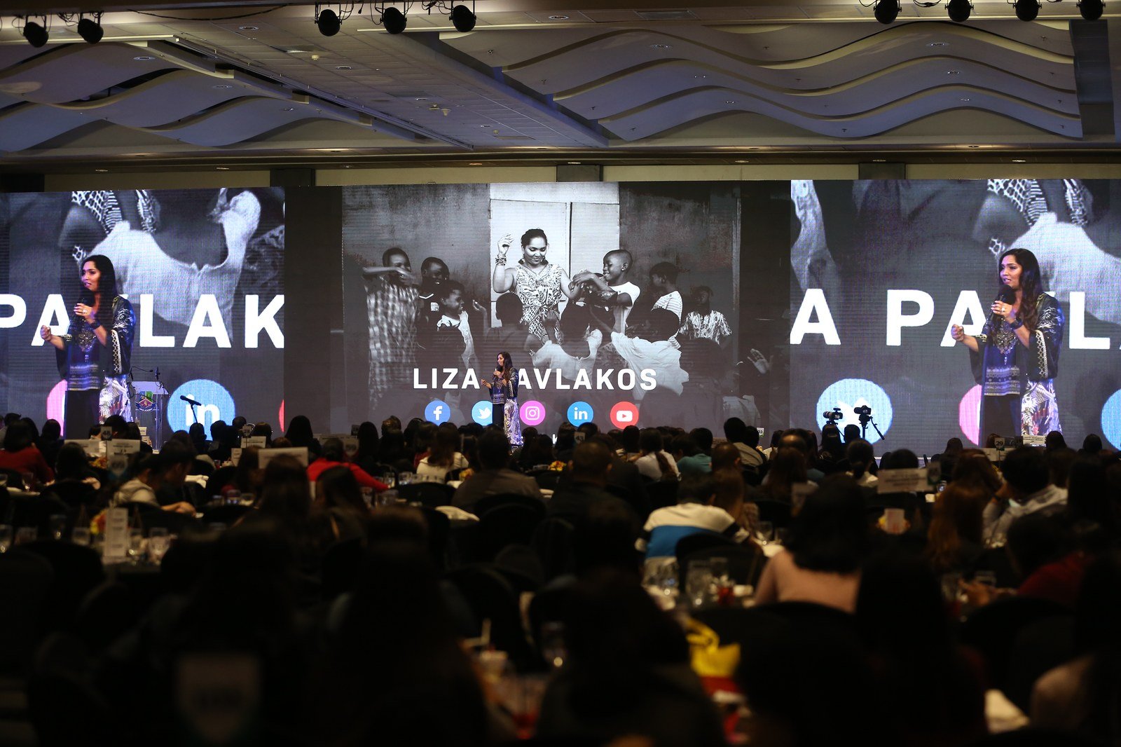 Norliza on stage in white dress — keynote speaker
