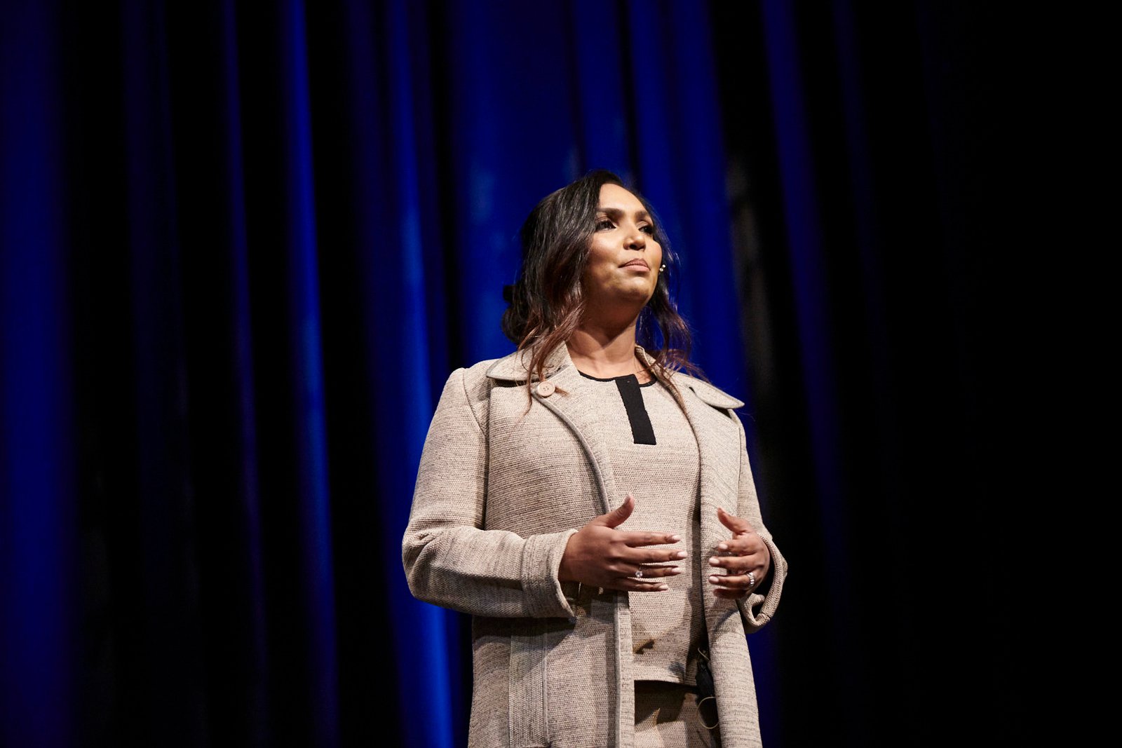 Norliza on stage — beige coat, blue stage lighting
