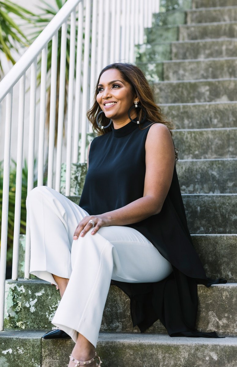 Norliza Pavlakos seated on stone steps, smiling