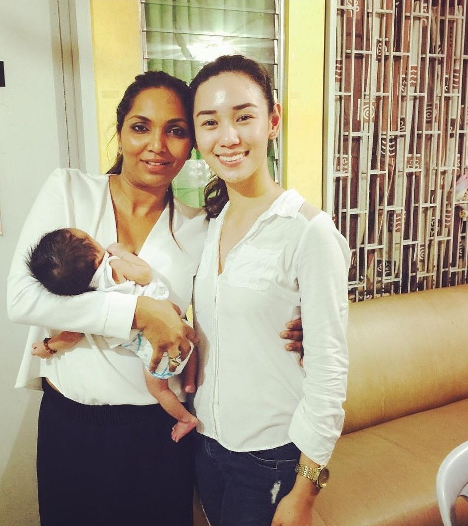 Norliza holding a newborn at a maternity home